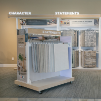 Carpet showroom display with hanging samples in gray and beige tones.